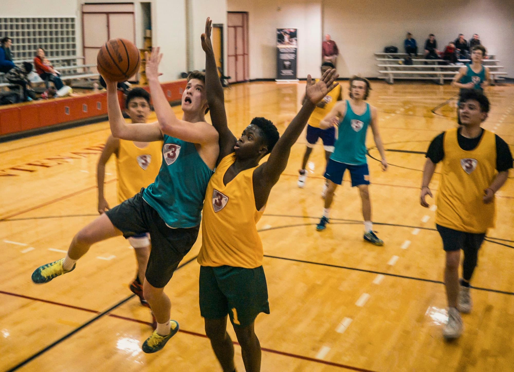 Joueurs de basket au duel sous le panier, dans un gymnase